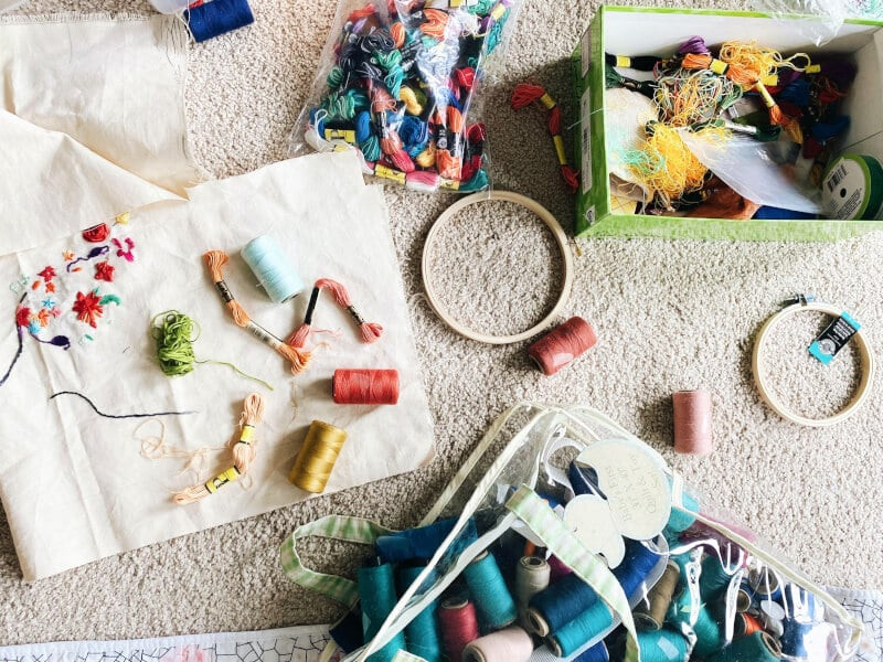 An embroidery kit full of colourful thread, hoops and fabric.